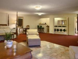 Merced Inn & Suites في ميرسيد: غرفة معيشة مع أريكة وطاولة