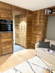 een woonkamer met een bank en houten kasten bij Megève Rochebrune, superbe appartement avec jardin in Megève