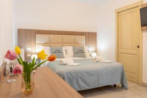 een slaapkamer met een bed met een vaas met bloemen bij Corte San Lorenzo in Sant'Egidio del Monte Albino