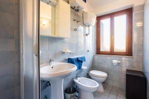 a white bathroom with a sink and a toilet at Villa Panoramica Costa Paradiso in Costa Paradiso +22 photos