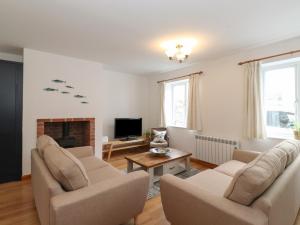 a living room with two chairs and a fireplace at Coastal Nest 30 Union Street in Seahouses