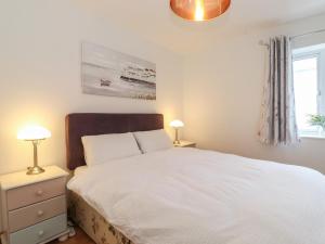 a bedroom with a white bed and two lamps at Coastal Nest 30 Union Street in Seahouses