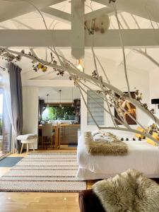 a living room with a bed and a tree at Cabane Spa Sauna in Ville-sur-Jarnioux