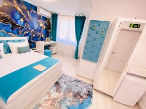 a blue and white bedroom with a bed and a door at IANIS Rooms in Mangalia