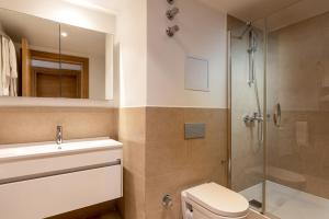 a bathroom with a shower and a toilet and a sink at Hiddenbay Teos Sığacık Hotel, Spa and Restaurants in Seferihisar