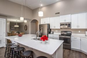 a kitchen with white cabinets and a kitchen island with stools at W307 Third Floor 3-bedroom Pool View in St. George