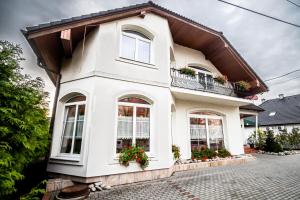 a white house with windows and a balcony at Hotel Squash Centrum in Prievidza