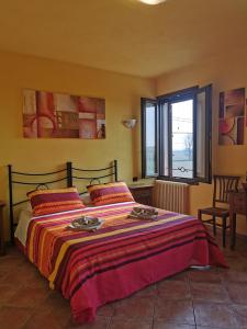 a bedroom with a bed with a colorful blanket at Casa di Campagna B&B La Corte Ferrara in Ferrara