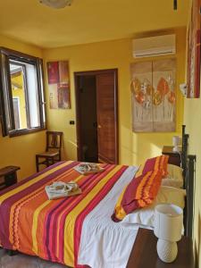 um quarto com uma cama com um cobertor colorido em Casa di Campagna B&B La Corte Ferrara em Ferrara