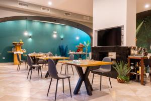 a restaurant with wooden tables and chairs and a blue wall at Corte San Lorenzo in Sant'Egidio del Monte Albino