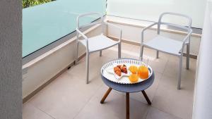 um prato de laranjas e duas cadeiras numa varanda em Marisa Apartments Hvar II em Hvar