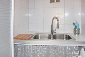 a kitchen sink with a wooden cutting board next to it at Haus Zeitlos Brunnenblick in Lübbenau