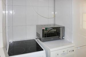 a kitchen with a microwave and a dishwasher at Haus Zeitlos Brunnenblick in Lübbenau