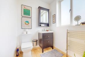 een badkamer met een toilet, een wastafel en een spiegel bij Charming 1 bedroom apartment in Finsbury Park in Londen