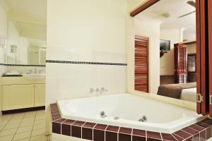 un bagno con vasca e una camera da letto. di Mantra on the Inlet a Port Douglas