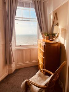 Habitación con silla frente a una ventana en Stunning seafront apartment, en Brighton & Hove