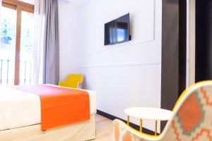 a bedroom with a bed and a table and chairs at Hotel Boutique Puerta de las Granadas in Granada