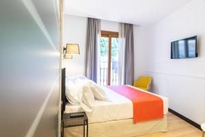 a bedroom with a bed and a mirror at Hotel Boutique Puerta de las Granadas in Granada