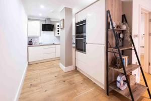 a kitchen with white cabinets and a wooden floor at Riverside House Bristol in Bristol