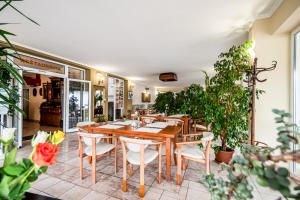 a dining room with a table and chairs and plants at Hotel Squash Centrum in Prievidza