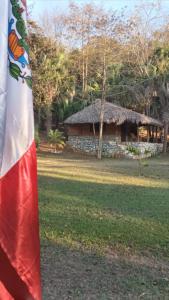 a flag in front of a stone house at Room in Cabin - Cabins Sierraverde Huasteca Potosina sierra cabin in Damían Carmona