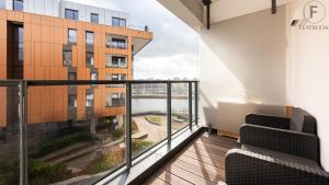 a balcony with chairs and a view of a building at Flatbook - City Center Apartments Brabank with Parking in Gdańsk