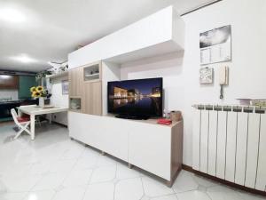 uma cozinha com uma televisão numa parede branca em Casa Zila em Finale Ligure
