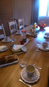 einem Holztisch mit Teller mit Lebensmitteln darauf in der Unterkunft La Maison Du Canal in Houdelaincourt