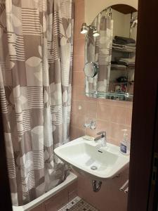 La salle de bains est pourvue d'un lavabo et d'un rideau de douche. dans l'établissement Haus Lith - Fewo Olesen, à Nordstrand