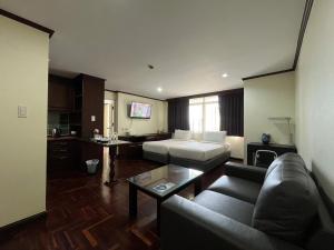 een woonkamer met een bank en een bed bij Yellow Ribbon Hills Boutique Suites in Bangkok