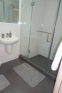 een badkamer met een douche en een wastafel bij Gallery suites and Apartments in Accra