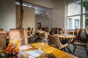 un restaurante con mesas y sillas de madera y ventanas en Hotel Fontána, en Brno