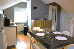 ein Esszimmer mit einem Tisch und einer Küche in der Unterkunft Cosynest in Amnéville