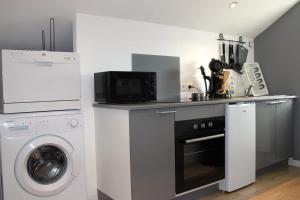 a kitchen with a washing machine and a microwave at Cosynest in Amnéville