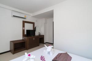 a room with a bed and a tv and a mirror at Destination Patong in Patong Beach