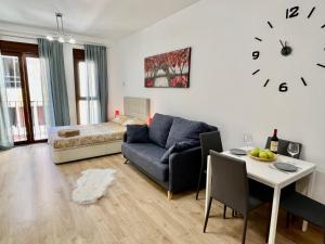salon z kanapą, stołem i zegarem w obiekcie Dream Loft w Alicante