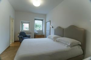 1 dormitorio con 1 cama blanca grande y 1 silla azul en Agriturismo Ai Prati, en Perugia