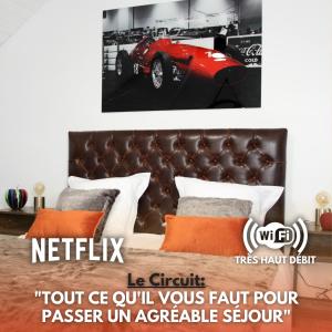 1 dormitorio con 1 cama con un coche rojo en la pared en Le Circuit - Tout simplement: confort!, en Cosne-Cours-sur-Loire