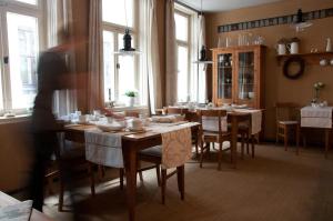 ein Esszimmer mit Tisch, Stühlen und Fenstern in der Unterkunft Hotel am Hoken in Quedlinburg