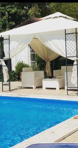 een witte parasol naast een zwembad bij Appartamento lussuoso 2 in Villa Riccardo Barga in Barga