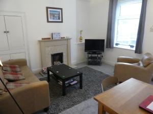 a living room with couches and a television and a fireplace at Rowland House - Central Skipton, Dales Gateway in Skipton