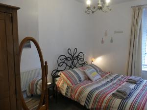 a bedroom with a bed with a mirror next to it at Rowland House - Central Skipton, Dales Gateway in Skipton