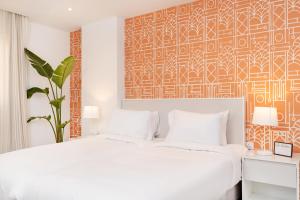 a bedroom with a white bed and a orange and white wall at Brassbell apartments by the Pyramids in Cairo