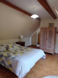 a bedroom with a large bed and a cabinet at Le Relais des Trois Cépages in Sassetot-le-Mauconduit