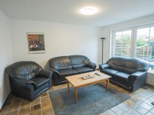 - un salon avec deux canapés en cuir et une table basse dans l'établissement Ferienhaus Gerth, FeWo Vermittlung Nordsee, à Dangast