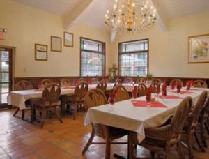 a large dining room with tables and chairs and a chandelier at Merced Inn & Suites in Merced