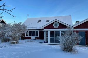 Hestra的住宿－Familjevänligt hus nära Isaberg!，前面有雪的红色谷仓