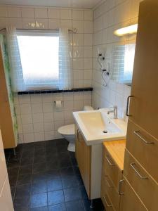 a bathroom with a sink and a toilet and a window at Familjevänligt hus nära Isaberg! in Hestra