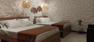 1 Schlafzimmer mit 2 Betten, einem Tisch und Kronleuchtern in der Unterkunft La Casa de Nelly - Medellín in Medellín
