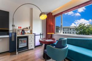 a living room with a blue couch and a window at Houhai Hotel in Beijing